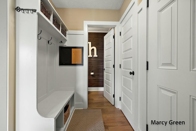 mudroom featuring wood finished floors and baseboards