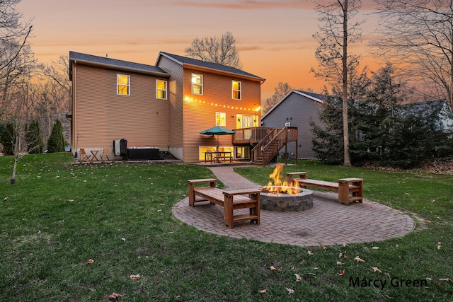 back of property featuring a wooden deck, a patio area, a lawn, stairs, and an outdoor fire pit