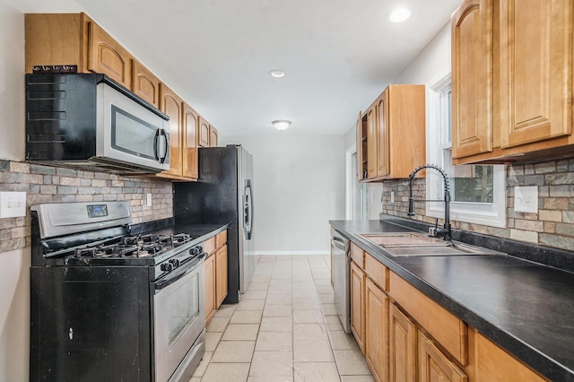 1511 Lake Ave, Portage, MI 49002 - kitchen with stainless steel appliances, a sink, dark countertops, baseboards, and backsplash