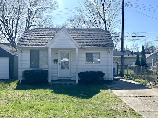 bungalow-style house with fence and a front lawn