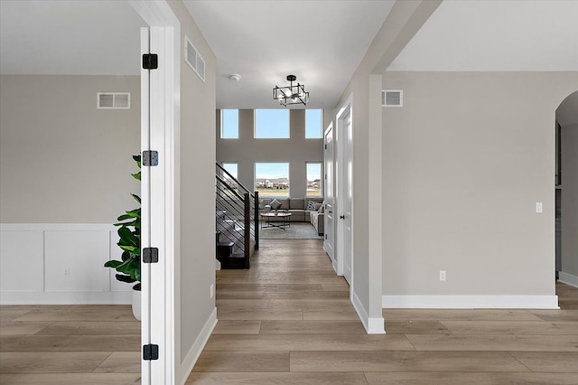 corridor featuring stairway, visible vents, and light wood-style flooring