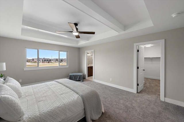 bedroom featuring light colored carpet, baseboards, and a tray ceiling