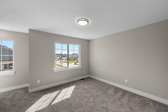 unfurnished room with visible vents, carpet flooring, and baseboards