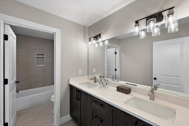 full bath featuring double vanity, tile patterned floors, toilet, and a sink