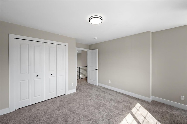 unfurnished bedroom featuring baseboards, a closet, and carpet