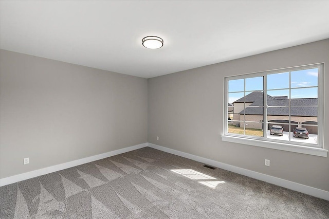 carpeted empty room with baseboards and visible vents