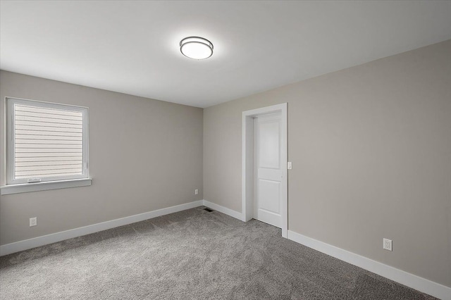 carpeted spare room with baseboards
