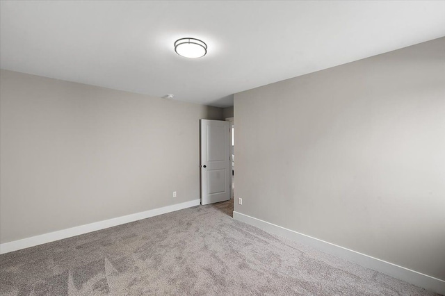 carpeted empty room featuring baseboards