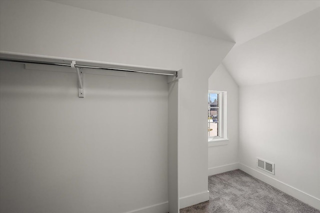 spacious closet with carpet floors, lofted ceiling, and visible vents