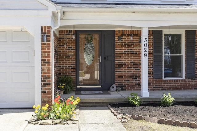 3029 Turnberry Ln, Ann Arbor, MI 48108 - property entrance with an attached garage, brick siding, and covered porch
