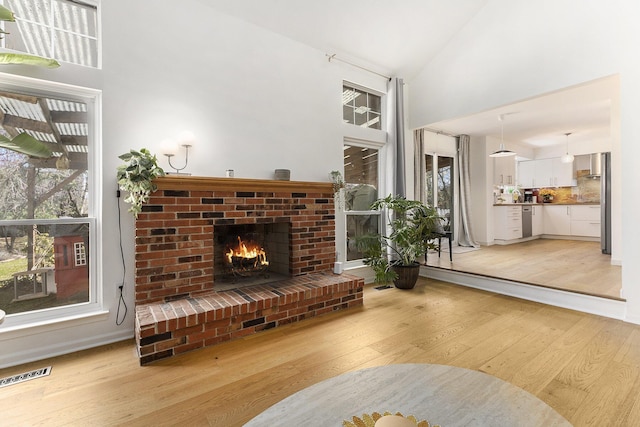 3029 Turnberry Ln, Ann Arbor, MI 48108 - living room with a healthy amount of sunlight, light wood-style flooring, visible vents, and a fireplace