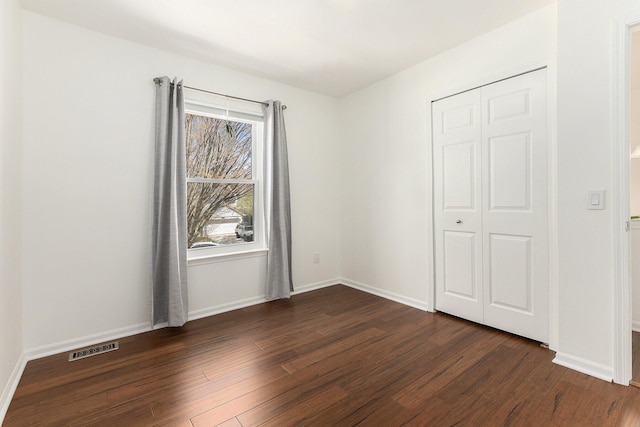 3029 Turnberry Ln, Ann Arbor, MI 48108 - unfurnished bedroom with baseboards, dark wood-style flooring, visible vents, and a closet