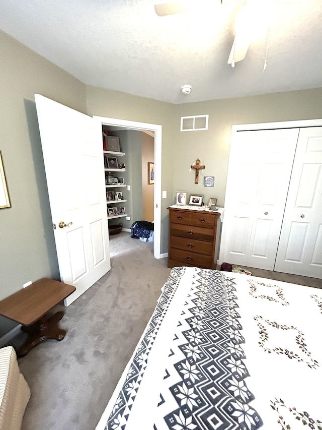 bedroom featuring ceiling fan, visible vents, carpet, and a closet