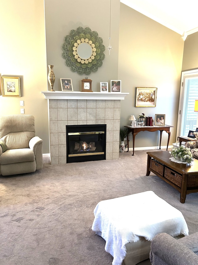 living area featuring ornamental molding, carpet flooring, and a tile fireplace
