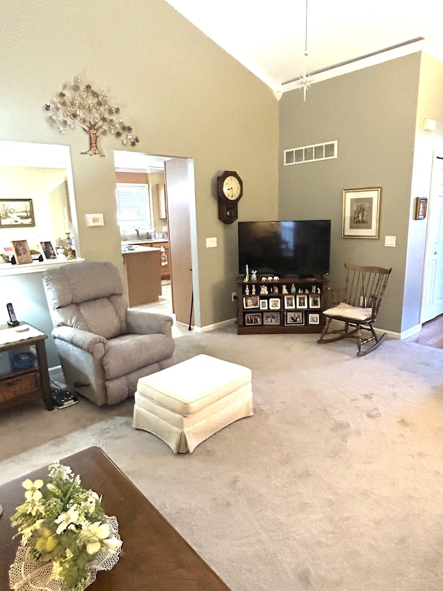 carpeted living area featuring high vaulted ceiling, baseboards, and visible vents