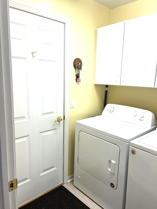 laundry area featuring separate washer and dryer and cabinet space
