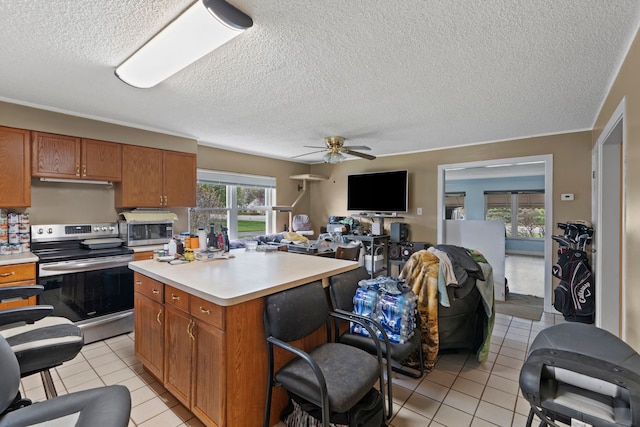 1401 S Williams Lake Rd, Waterford, MI 48327 - kitchen with appliances with stainless steel finishes, light countertops, a textured ceiling, light tile patterned floors, and brown cabinets