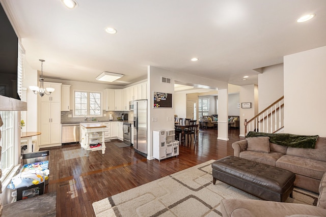 living area featuring recessed lighting, dark wood-style flooring, stairway, and visible vents