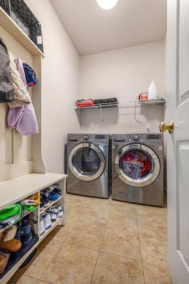 laundry room with tile patterned floors, washing machine and clothes dryer, and laundry area