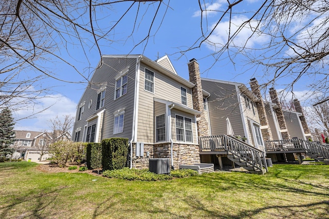 view of property exterior featuring a wooden deck, stairway, central AC unit, a lawn, and stone siding