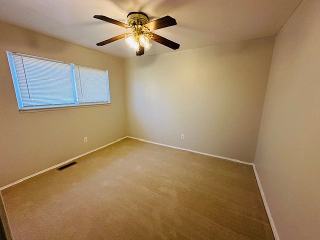 819 Frank Ave, Lincoln Park, MI 48146 - unfurnished room with ceiling fan, baseboards, visible vents, and carpet floors