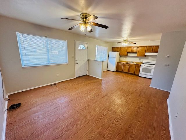 819 Frank Ave, Lincoln Park, MI 48146 - kitchen with light wood-style floors, ceiling fan, white appliances, brown cabinetry, and baseboards