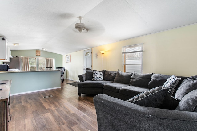 living room featuring ceiling fan, dark wood-style floors, a wealth of natural light, and lofted ceiling