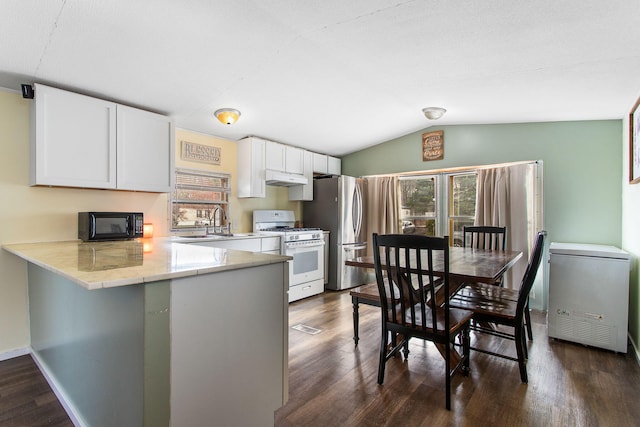 kitchen featuring plenty of natural light, refrigerator, black microwave, and white gas range