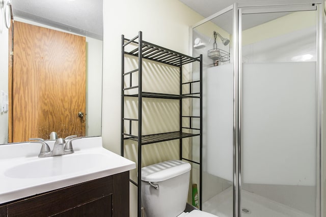 bathroom featuring vanity, a stall shower, and toilet