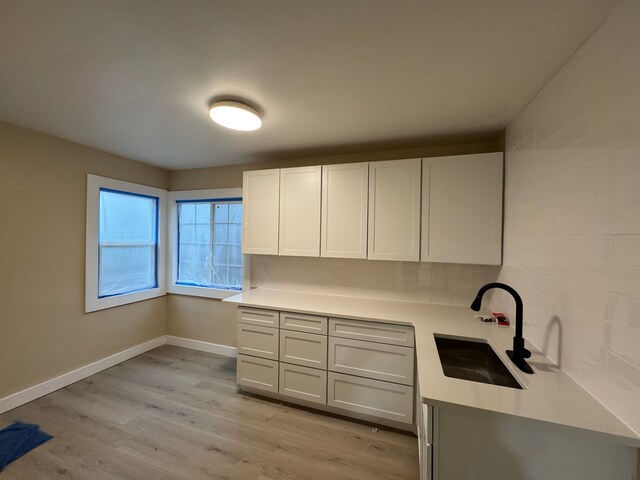 1338 Helen St, Inkster, MI 48141 - kitchen with a sink, light countertops, baseboards, and light wood finished floors