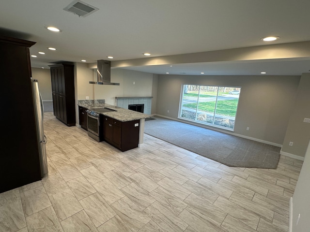 kitchen featuring baseboards, visible vents, range hood, and appliances with stainless steel finishes