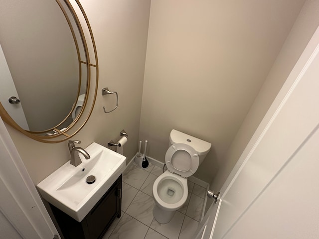 bathroom with baseboards, marble finish floor, vanity, and toilet