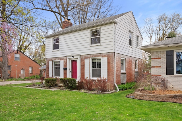 11310 Ingram St, Livonia, MI 48150 - view of front of home featuring a chimney, a front yard, and brick siding