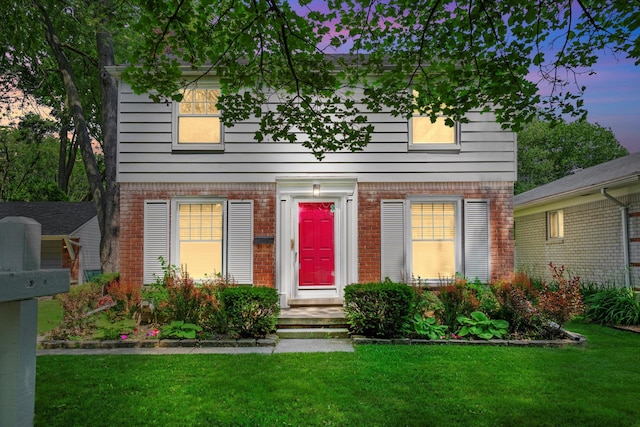 11310 Ingram St, Livonia, MI 48150 - colonial house featuring brick siding and a lawn