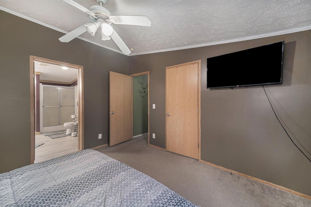 bedroom featuring a textured ceiling, carpet flooring, ornamental molding, and connected bathroom