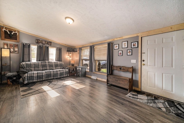 living room with lofted ceiling, baseboards, wood finished floors, and a textured ceiling