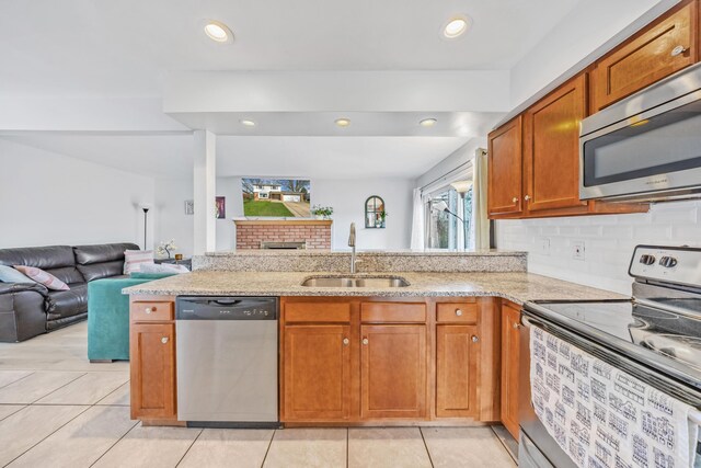 29772 Brentwood St, Southfield, MI 48076 - kitchen with light stone counters, stainless steel appliances, light tile patterned floors, a sink, and open floor plan