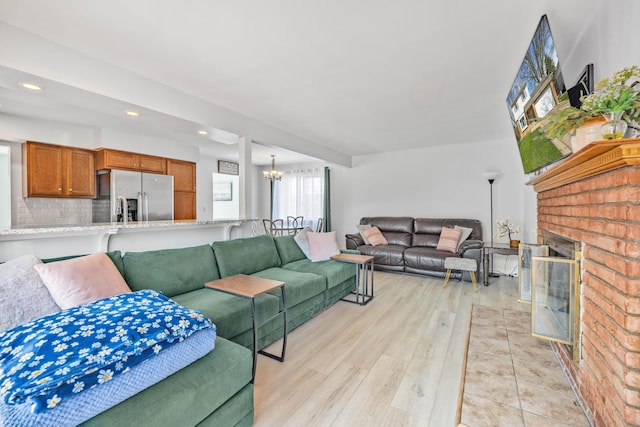 29772 Brentwood St, Southfield, MI 48076 - living area featuring a fireplace, recessed lighting, a notable chandelier, and light wood-style flooring