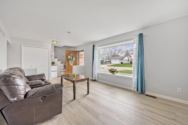 29772 Brentwood St, Southfield, MI 48076 - living area featuring baseboards, stairs, visible vents, and light wood-style flooring