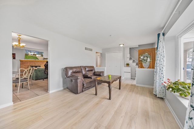 29772 Brentwood St, Southfield, MI 48076 - living area featuring light wood finished floors, visible vents, baseboards, stairs, and a notable chandelier