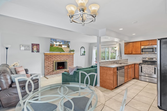 29772 Brentwood St, Southfield, MI 48076 - kitchen with a sink, a chandelier, brown cabinetry, appliances with stainless steel finishes, and open floor plan