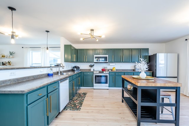 1216 Ellery Grove Ct, Vicksburg, MI 49097 - kitchen featuring a sink, light wood-style floors, a chandelier, stainless steel appliances, and decorative light fixtures