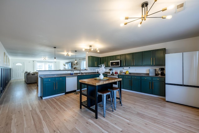 1216 Ellery Grove Ct, Vicksburg, MI 49097 - kitchen featuring stainless steel appliances, a peninsula, a sink, dark countertops, and a chandelier