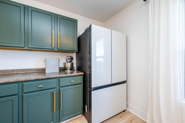 1216 Ellery Grove Ct, Vicksburg, MI 49097 - kitchen with baseboards, dark countertops, light wood-style floors, and freestanding refrigerator