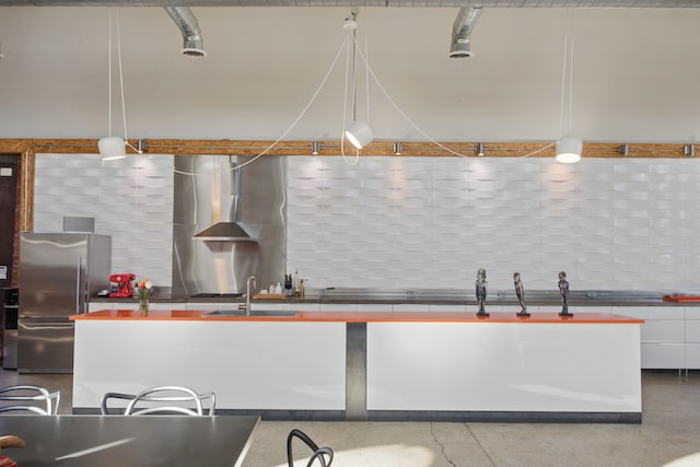 3401 Michigan Ave, Detroit, MI 48216 - kitchen featuring a sink, freestanding refrigerator, white cabinetry, wall chimney range hood, and tasteful backsplash