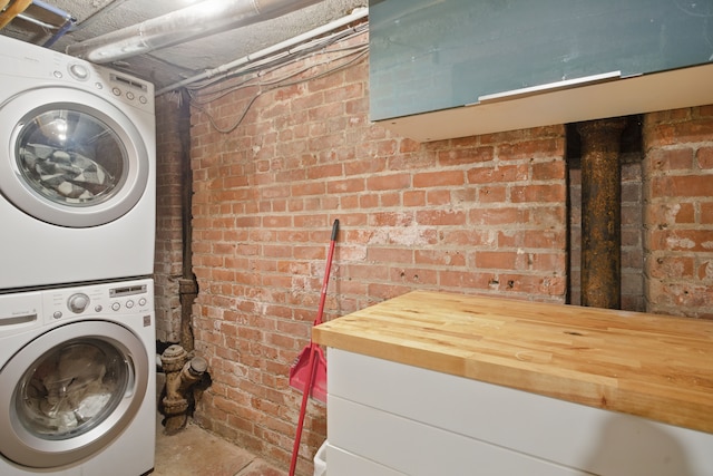 3401 Michigan Ave, Detroit, MI 48216 - clothes washing area featuring stacked washer and clothes dryer and brick wall