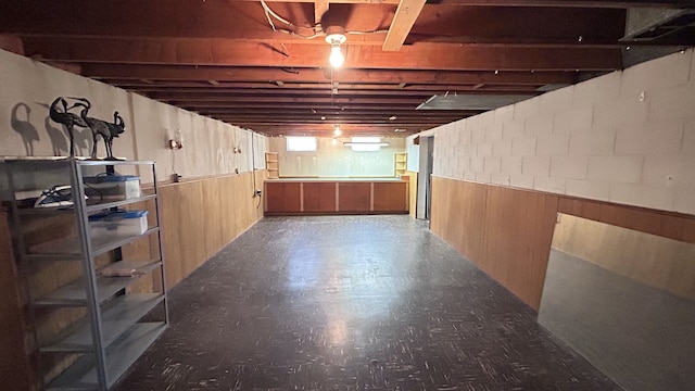 basement with wood walls and tile patterned floors