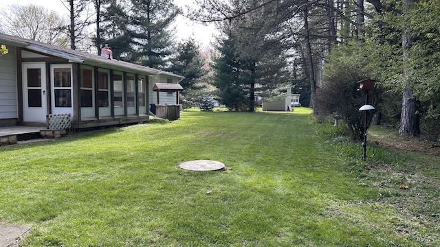 view of yard featuring an outbuilding and a sunroom