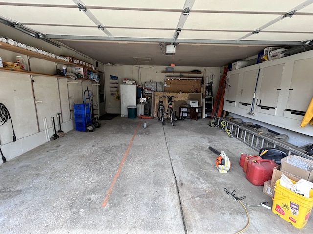 garage featuring freestanding refrigerator and a garage door opener