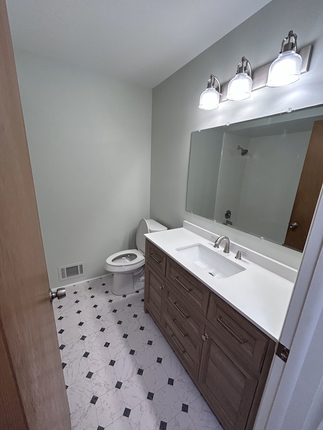bathroom with visible vents, vanity, a shower, toilet, and tile patterned floors